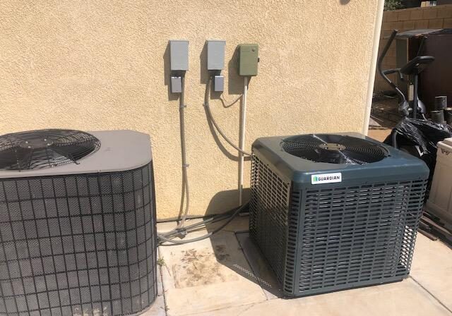 Two air conditioners outside a home.